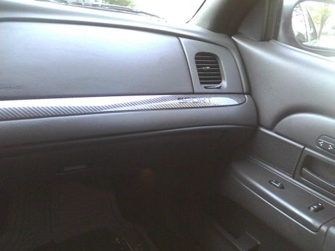 2003 Ford Crown Victoria - The interior of a car shows the dashboard with a carbon fiber-style trim piece.
