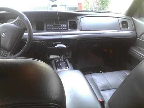 2003 Ford Crown Victoria - The interior of a 2003 Ford Crown Victoria is visible from the rear passenger seat.