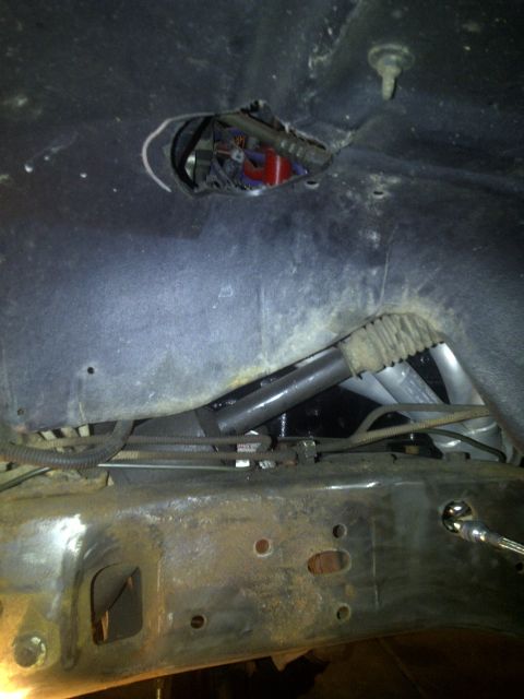 1995 Ford Bronco - Close-up view of a vehicle's undercarriage, revealing mechanical components and wiring.