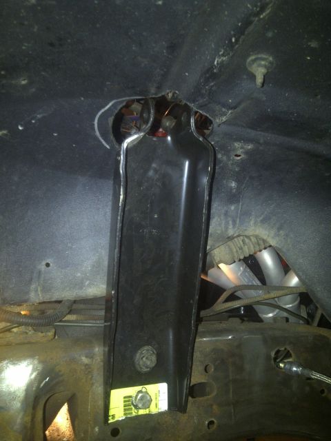 1995 Ford Bronco - A yellow sticker with text is visible on a black suspension component, likely part of a vehicle's undercarriage.