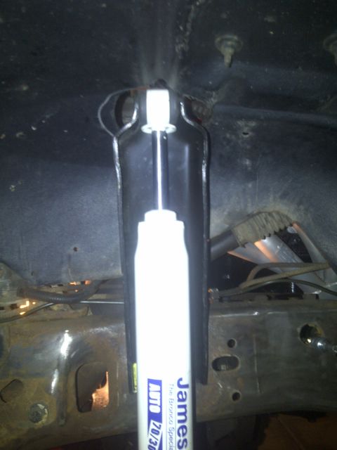 1995 Ford Bronco - Close-up of a shock absorber, part of a vehicle's undercarriage.