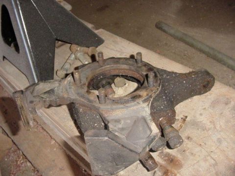 1992 Ford Bronco - Dana 44 knuckle assembly resting on wood, with a jack stand visible.