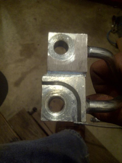 1995 Ford Bronco - Close-up of a metal bracket with two holes and a pipe, likely a vehicle part.