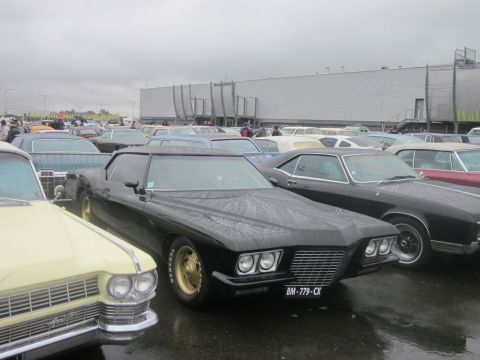 1991 Ford LTD Crown Victoria - A black coupe with gold wheels is parked in a lot filled with other classic cars.