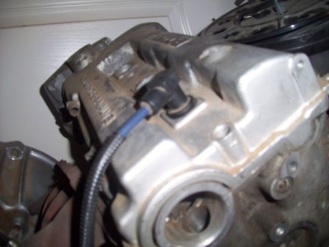 1995 Ford Probe - Close-up view of an engine component, possibly a cylinder head, with a spark plug wire connected.