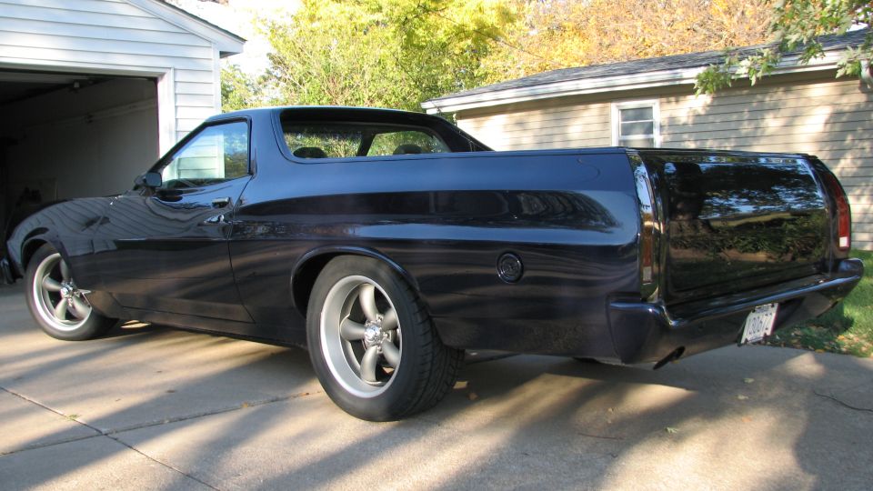 Dark blue 1973 Ford Ranchero with custom wheels parked in a driveway