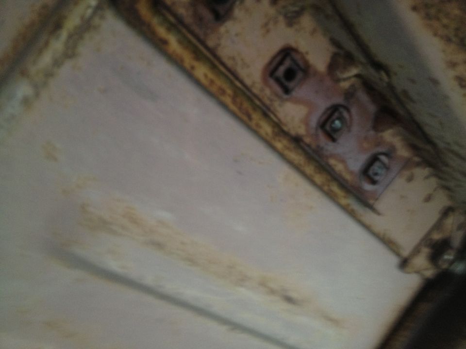 Underside of vehicle frame with rust and mounting points