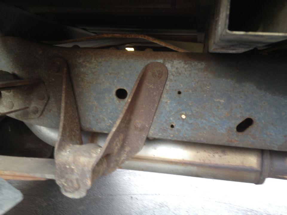 rusted truck frame section with visible exhaust pipe and mounting bracket
