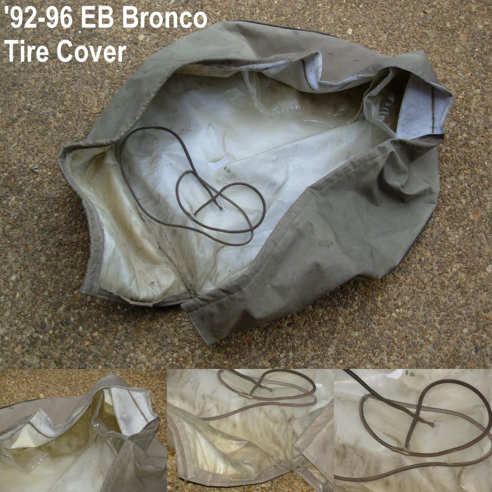 Worn gray 1992-96 Eddie Bauer Bronco spare tire cover laid out on pavement
