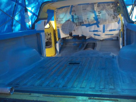 1978 Ford Bronco - Vehicle interior is masked and covered with a blue tarp, ready for painting. Newspaper is used to cover the windows.