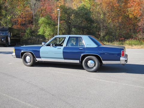 1991 Ford LTD Crown Victoria - This sedan features a distinct two-tone paint scheme, with the front half in light blue and the rear half in dark blue.