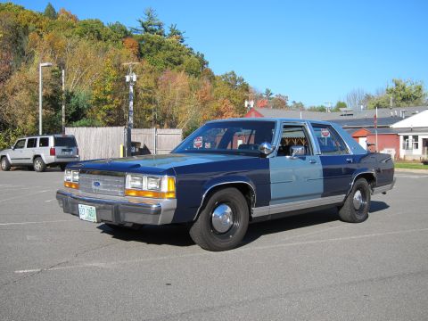 1991 Ford LTD Crown Victoria - A two-tone Ford Crown Victoria is parked in an outdoor lot on a sunny day.