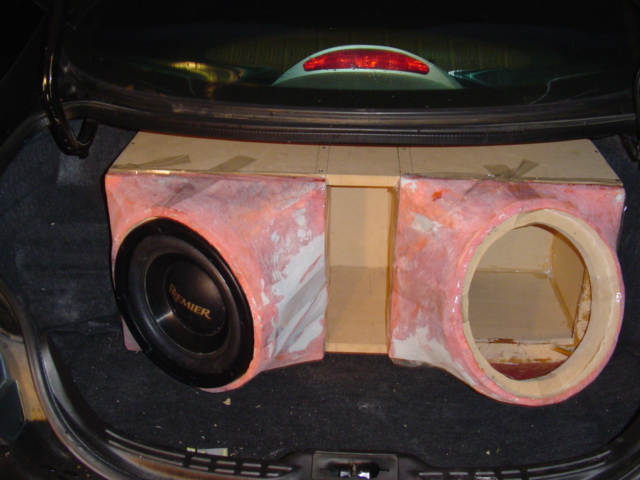 Custom pink fiberglass dual sub box in car trunk with one Pioneer Premier subwoofer installed