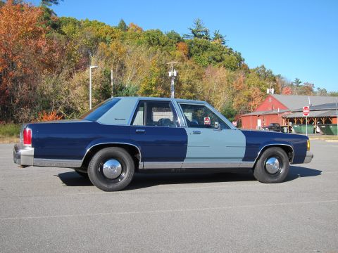 1991 Ford LTD Crown Victoria - A two-tone 1991 Ford Crown Victoria LTD is parked outdoors on a sunny day with autumn foliage in the background.
