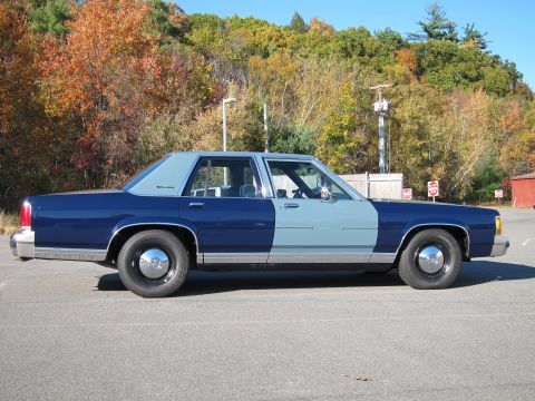 1991 Ford LTD Crown Victoria - Side view of a two-tone 1991 Ford Crown Victoria LTD sedan parked in a lot during autumn.