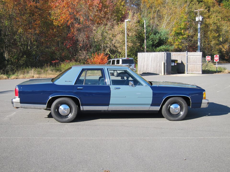 Side view of a two-tone blue and light blue 1991 Ford Crown Victoria LTD parked in a lot