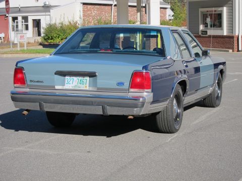 1991 Ford LTD Crown Victoria - The rear of a two-tone blue 1991 Ford Crown Victoria LTD is shown from a low angle.