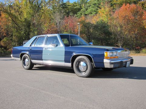 1991 Ford LTD Crown Victoria - This 1991 Ford Crown Victoria LTD sedan features a distinctive two-tone blue paint scheme and is seen here in a three-quarter front view.