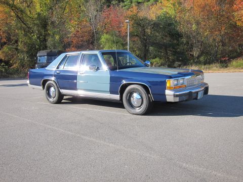 1991 Ford LTD Crown Victoria - This 1991 Ford Crown Victoria LTD sedan is seen from a three-quarter front angle with a two-tone blue paint scheme.