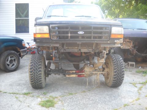 1982 Ford Bronco - Front end of a Ford truck, likely from the 1990s, with its bumper removed and suspension visible.