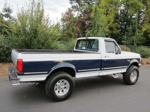 1992 Ford F-250 - This two-tone blue and white 1992 Ford F-250 pickup truck is shown from a three-quarter front perspective.
