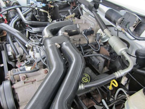 1992 Ford F-250 - Close-up of a vehicle's engine bay, prominent black intake piping and a Ford-branded oil cap.
