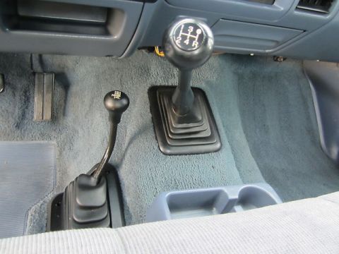 1992 Ford F-250 - The interior of a 1992 Ford F-250 showcases its manual transmission and 4WD selector lever.