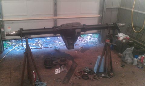 1995 Ford Bronco - A vehicle's rear axle assembly is shown disassembled and supported by jack stands in a garage setting.