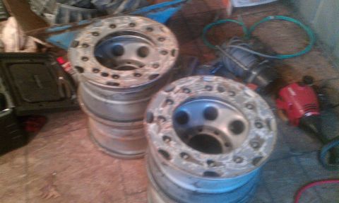 1995 Ford Bronco - Stacks of aluminum wheels are visible in a cluttered garage setting.