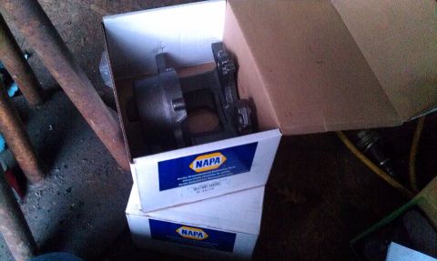 1995 Ford Bronco - Cardboard boxes containing NAPA brake caliper parts are stacked indoors.