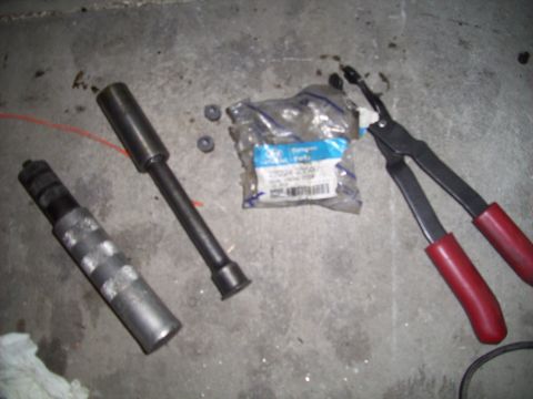 1995 Ford Probe - Tools and parts are laid out on a concrete surface, likely for a vehicle repair.