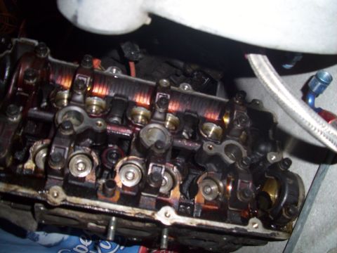 1995 Ford Probe - The internal components of an engine's valve cover are shown, covered in oil and grime.
