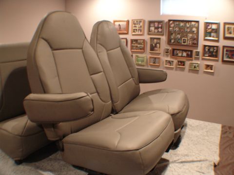 1992 Ford F-250 - Interior view of tan leather car seats with armrests against a wall with framed photos.