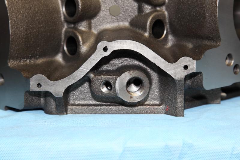 Close-up of an engine block casting with bolt holes and machined surfaces