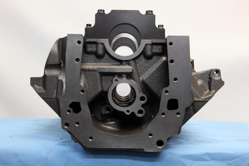 Black cast iron engine block with metal plates bolted to the top and sides