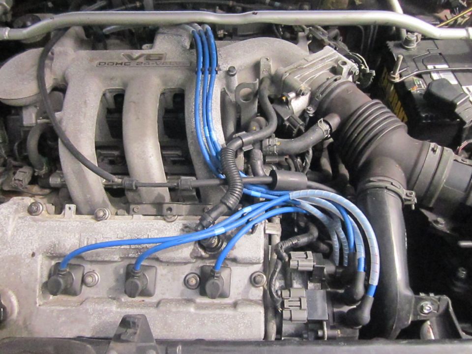 Engine bay of a 1993 Mazda MX-3 showing V6 DOHC 24-valve engine with blue spark plug wires
