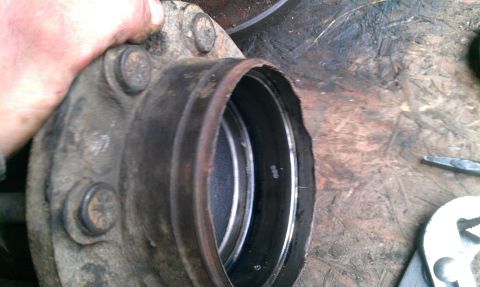 1995 Ford Bronco - A mechanic's hand holds a vehicle's wheel hub assembly during a repair.