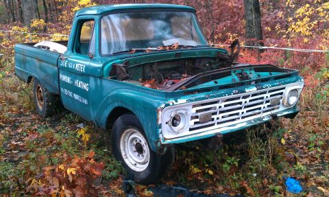 1995 Ford Bronco - This vintage pickup truck, likely from the mid-1960s, sits abandoned in a wooded area during autumn.