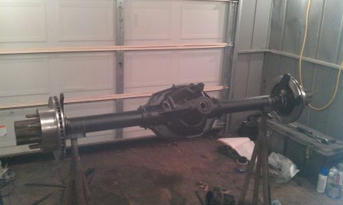 1995 Ford Bronco - A rear axle assembly with disc brakes is shown on stands in a garage setting.