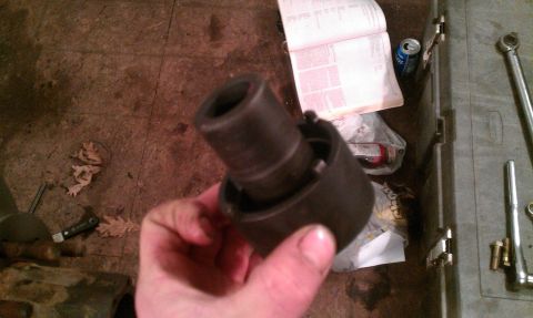 1995 Ford Bronco - A hand holds a socket wrench part, with tools and a manual in the background.