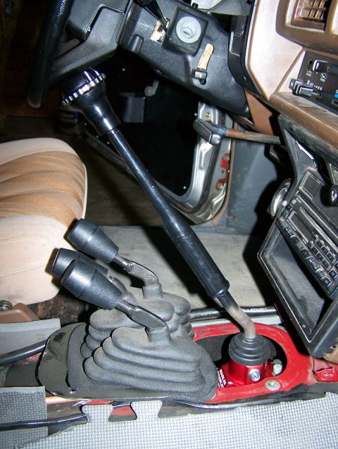 1988 Suzuki Samurai - The vehicle's interior features a complex shifter setup with a main gear stick and additional levers for four-wheel drive engagement.
