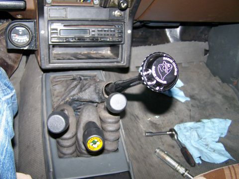 1988 Suzuki Samurai - The interior of a vehicle displays a shifter knob with custom text and a radio unit.