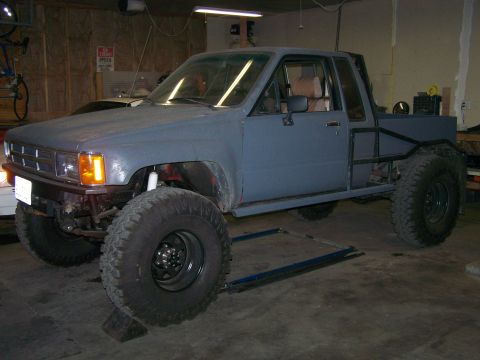 1988 Suzuki Samurai - This modified pickup truck has a custom roll cage and oversized tires, suggesting off-road use.