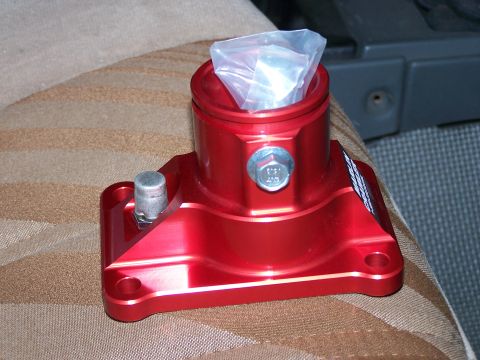 1988 Suzuki Samurai - A red aluminum automotive part sits on a striped seat, with a Supermotors.net watermark visible.