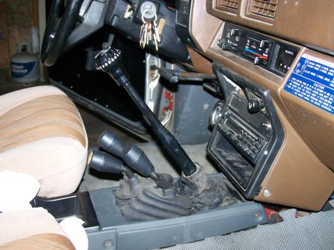 1988 Suzuki Samurai - The interior of a vehicle, focusing on the gear shifters and dashboard controls.