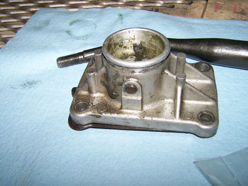 Used throttle body on blue shop towels, with a dark tool in background