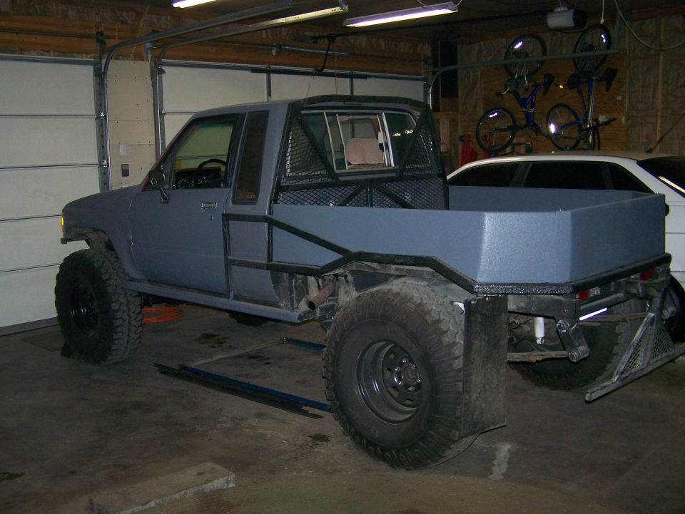 Pickup truck with custom flatbed and roll cage, painted gray