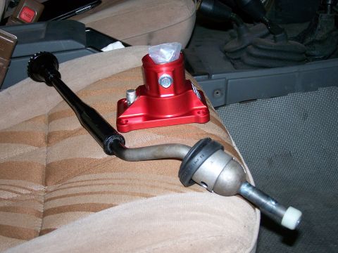 1988 Suzuki Samurai - Aftermarket shifter components are shown resting on a vehicle's seat.