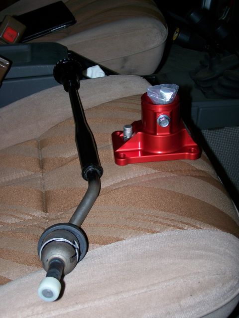 1988 Suzuki Samurai - A red shift knob base and shifter lever are shown on a car seat, suggesting an interior modification.