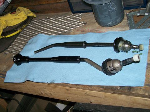 1988 Suzuki Samurai - Two gear shift levers are shown side-by-side on a workbench.